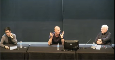 Three people seated at a lecture table